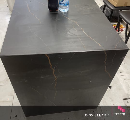 שולחן שיש כהה עם בקבוקי שתייה